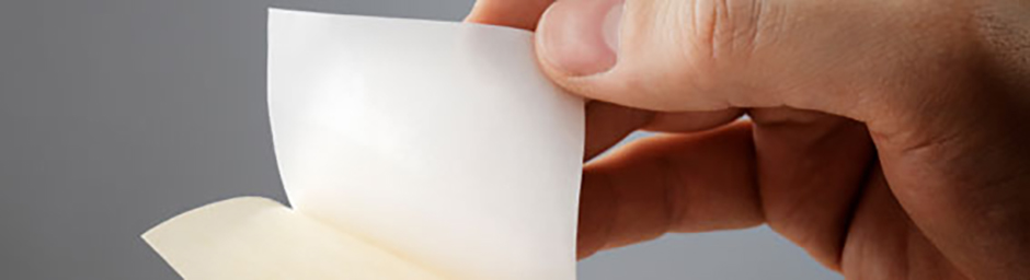 close up hand peeling adhesive backing