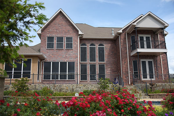 A large house made of bricks with a garden out front