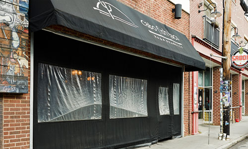 an awning made of black fabric set up in front of a building